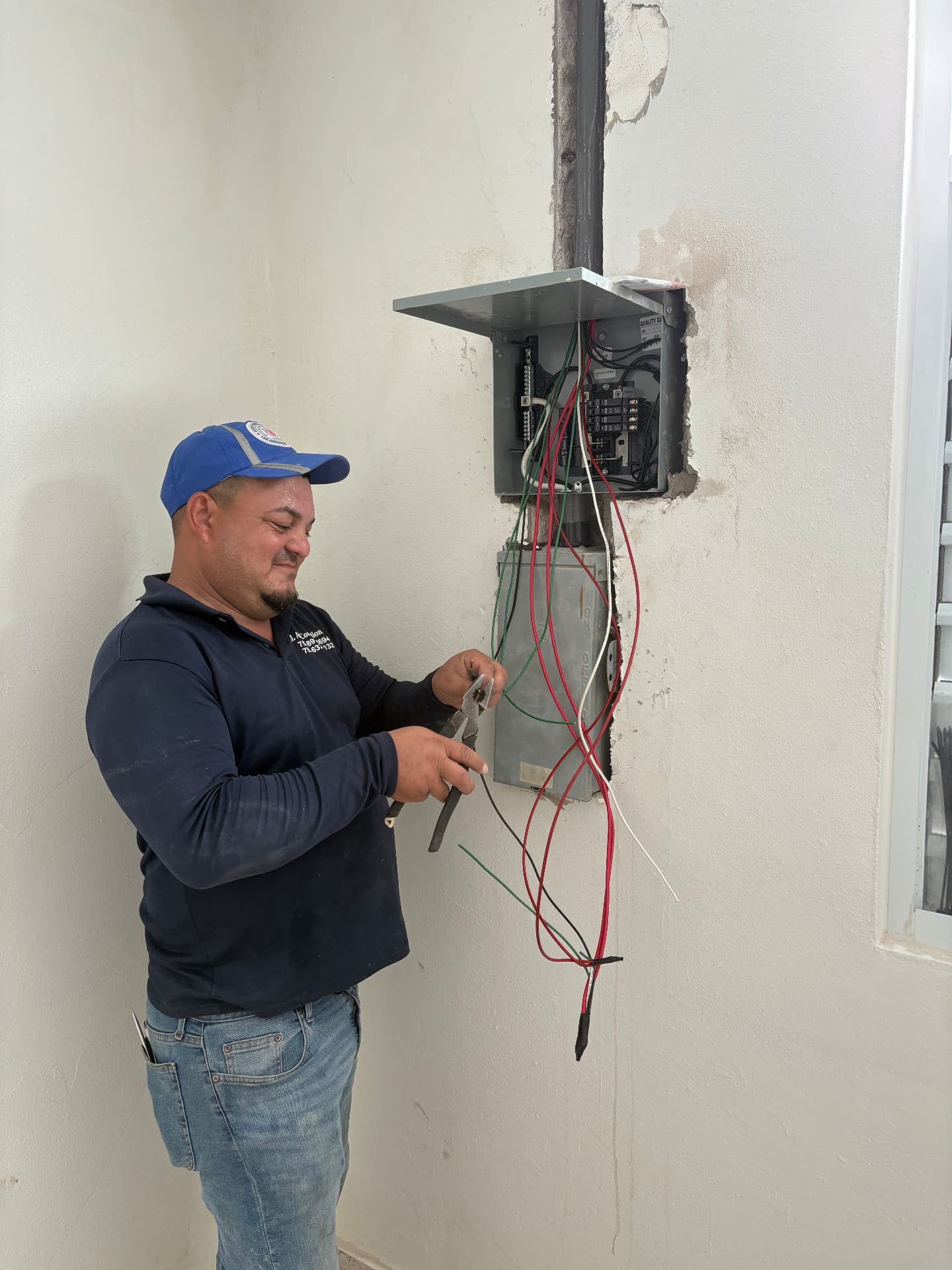 Técnico de JL instalando un centro de carga eléctrico con tubería EMT empotrada en pared